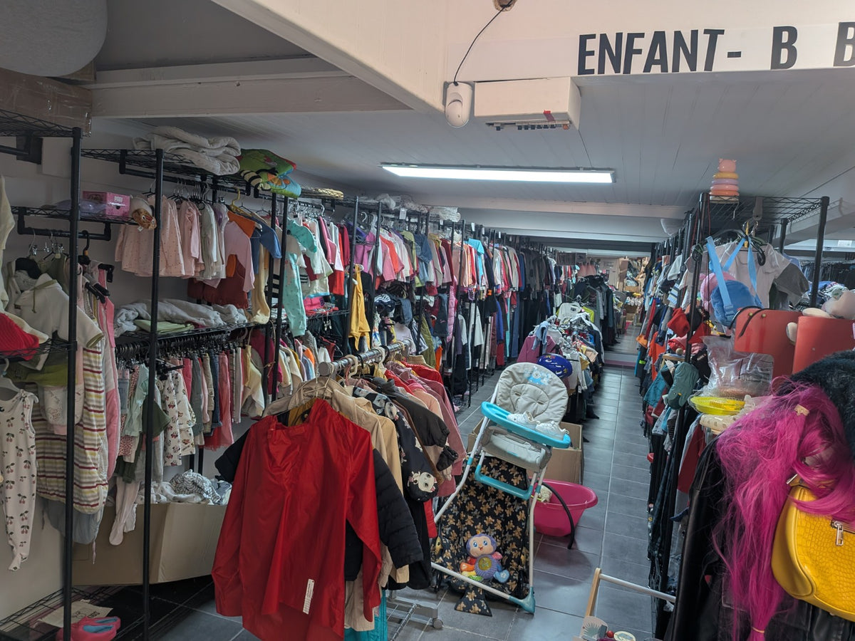 Vue réelle du rayon vêtements enfants Stanoccasion à Perpignan. Lot textile à retirer sur place ; équipements et objets non textiles non compris.